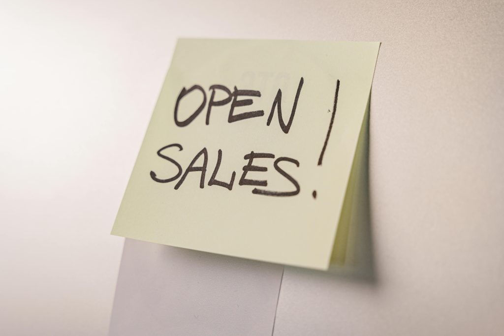 A close-up of an 'Open Sales' sticky note on a white background, ideal for business promotions.